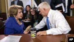 FILE - House Rules Committee Chairman Pete Sessions, R-Texas (C) , confers with Rep. Louise Slaughter, D-N.Y., the top Democrat, as the panel meets early Dec. 20, 2017, to approve some procedural corrections in the final version of the Republican tax bill, on Capitol Hill, in Washington.