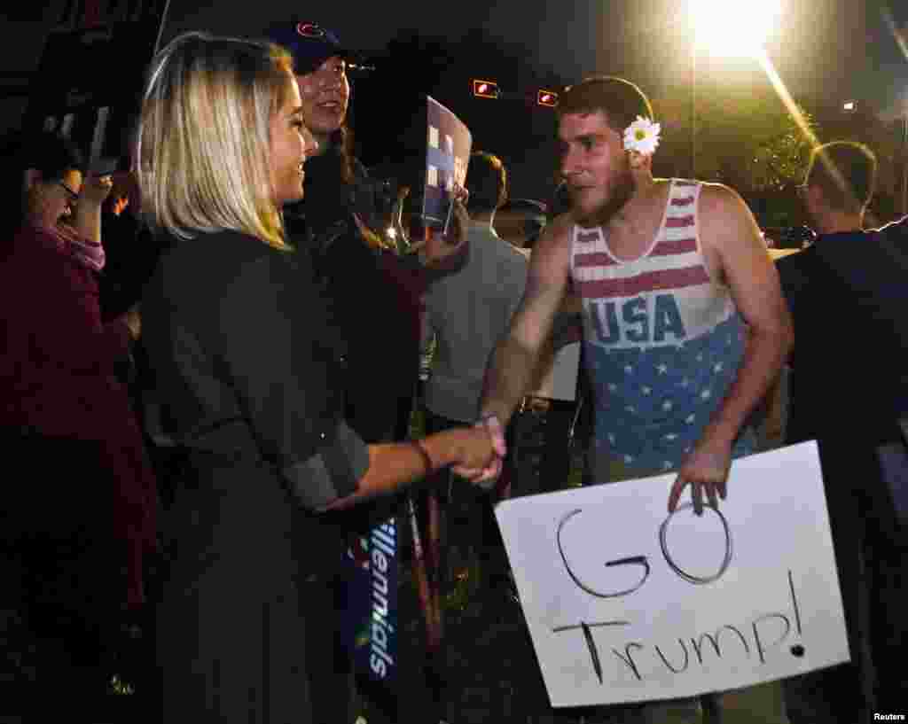 تظاهرات در ایالت فلوریدا، یک معترض ضد ترامپ با یک طرفدار ترامپ دست می&zwnj;&zwnj;دهد.&nbsp;