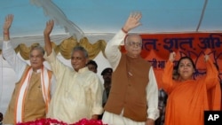 FILE - In this July 28, 2005 photo, President of the Bharatiya Janta Party (BJP) Lal Krishna Advani, second right, senior BJP leaders Uma Bharati, right, Kalyan Singh, second left, and Murli Manohar Joshi wave to people during a public rally in Rae Bareilly. India's top court said April 19, 2017, that the four senior leaders of the BJP Party will stand trial for their role in a criminal conspiracy over the destruction of the 16th century Babri mosque in 1992, an event that sparked bloody nationwide rioting. 