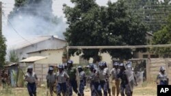 Police leave the scene after throwing teargas at a house in Chitungwiza, Zimbabwe, November 6, 2011.