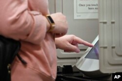 A woman casts her ballot ahead of the Nov. 6 general election at Jim Miller Park, Oct. 27, 2018, in Marietta, Ga.