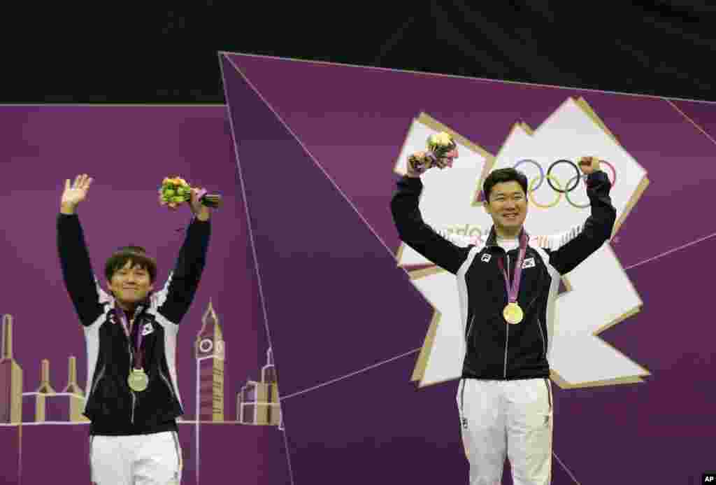 Gold medal winner, South Korea's Jin Jong-oh, right, celebrates with countryman Choi Young-rae, who took silver, during the victory ceremony for the men's 50-meter pistol, at the 2012 Summer Olympics, in London, August 5, 2012.