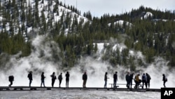 FILE - Visitors are seen at Grand Prismatic Spring in Yellowstone National Park, Wyoming, May 1, 2021.