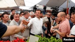 Ekrem Imamoglu, calon Wali Kota Istanbul dari partai oposisi Partai Rakyat Republik (CHP) menyalami penjual sayur di Istanbul, Turki, 29 Mei 2019.