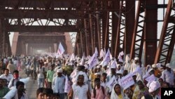 Peziarah Hindu membawa bendera-bendera keagamaan dan berjalan di jembatan yang padat orang setelah sebelumnya terjadi insiden orang terinjak-injak di jembatan yang sama (15/10/2016). Varanasi, India. (foto: AP Photo)