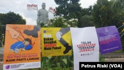 Poster yang dipasang dipagar kawat depan Gedung Negara Grahadi di Surbaya, Jawa Timur, yang berisi seruan penghentian kekerasan terhadap jurnalis dalam sebuah aksi pada Maret 2021. (Foto: VOA/Petrus Riski)
