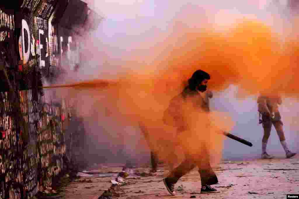 Riot police sprays powder on a demonstrator during a protest on International Women&#39;s Day, in Mexico City, Mexico, March 8, 2021.