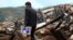 A man carries a picture as he stands among debris in the Longtoushan township of Ludian county, Yunnan province, Aug. 4, 2014