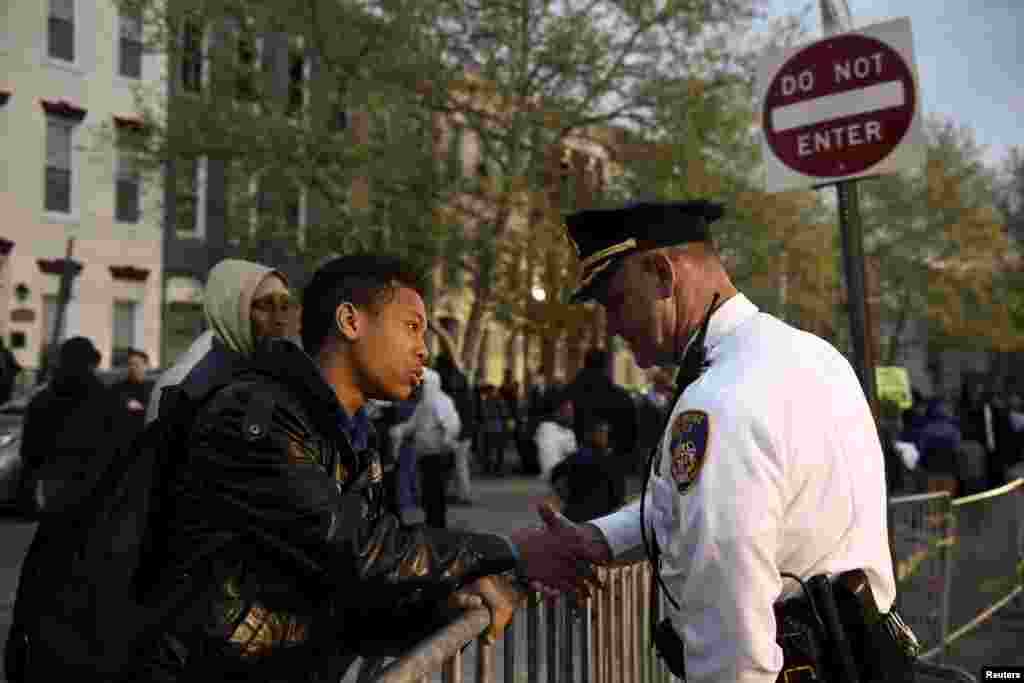Ninth-grader Tremaine Holmes shakes hands with Captain Erik Pecha in front of the Baltimore Police Department Western District station during a protest against the death in police custody of Freddie Gray in Baltimore, April 23, 2015.