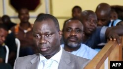 General Brunot Dogbo Ble, foreground, and Anselme Seka Yapo, ex-chief of security for former first lady Simone Gbagbo, attend their trial with other defendants in the killing of Robert Guei in Abidjan, Feb. 17, 2016. 