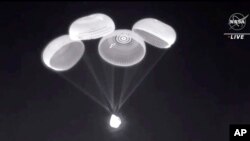 Imagen divulgada por la NASA de la cápsula Crew Dragon de SpaceX cuando descendía con cuatro astronautas en el Golfo de México el 8 de noviembre de 2021.