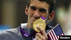 El nadador estadounidense Michael Phelps besa su medalla olímpica número 19, que obtuvo en Londres en la categoría de estilo libre 4X200 metros. 