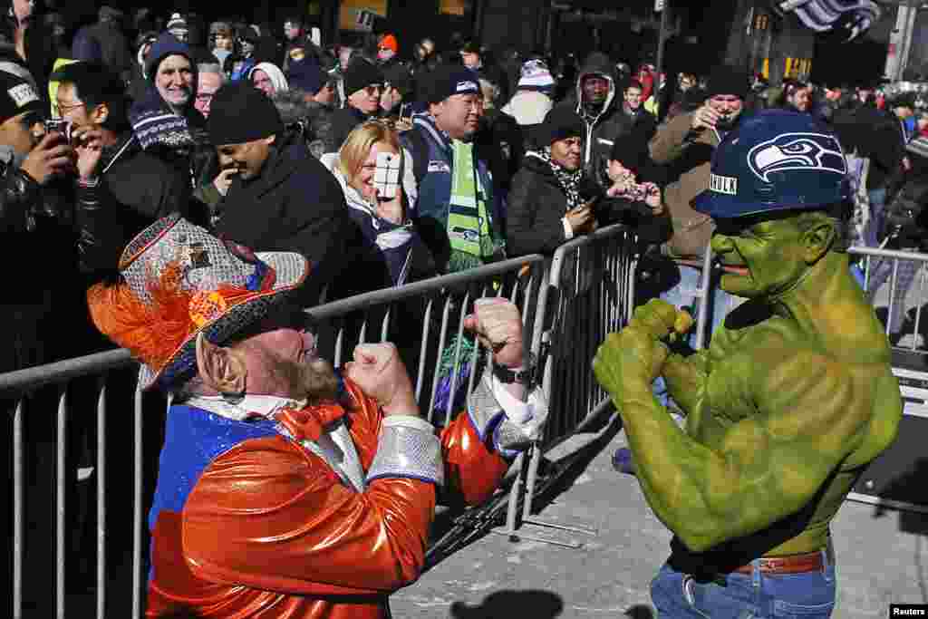 A fan of the Seattle Seahawks jokes with a fan of the Denver Broncos at the Super Bowl Boulevard fan zone ahead of Super Bowl XLVIII in New York, Jan. 30, 2014.