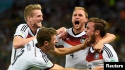 Germany's Mario Goetze celebrates his goal against Argentina with teammates (L-R) Andre Schuerrle ,Thomas Mueller and Benedikt Hoewedes during extra time in their 2014 World Cup final at the Maracana stadium in Rio de Janeiro July 13, 2014. 