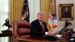 FILE - President Donald Trump answers questions from the media after speaking with members of the military by video conference on Christmas Day, Dec. 25, 2018, in the Oval Office of the White House. 
