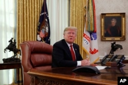 President Donald Trump answers questions from the media after speaking with members of the military by video conference on Christmas Day, Dec. 25, 2018, in the Oval Office of the White House.