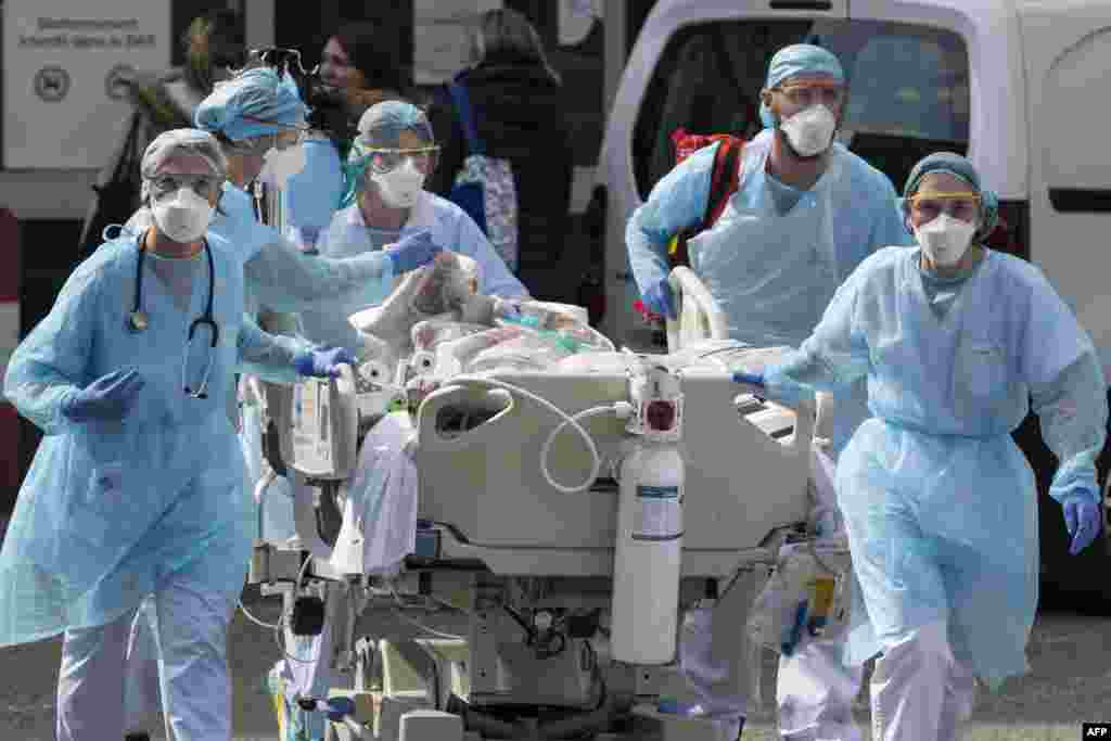 Medical staff move a patient to a medical helicopter at The Emile Muller Hospital in Mulhouse, eastern France, as patients are evacuated to another hospital facility, on the sixth day of a strict lockdown in France to stop the spread of COVID-19.