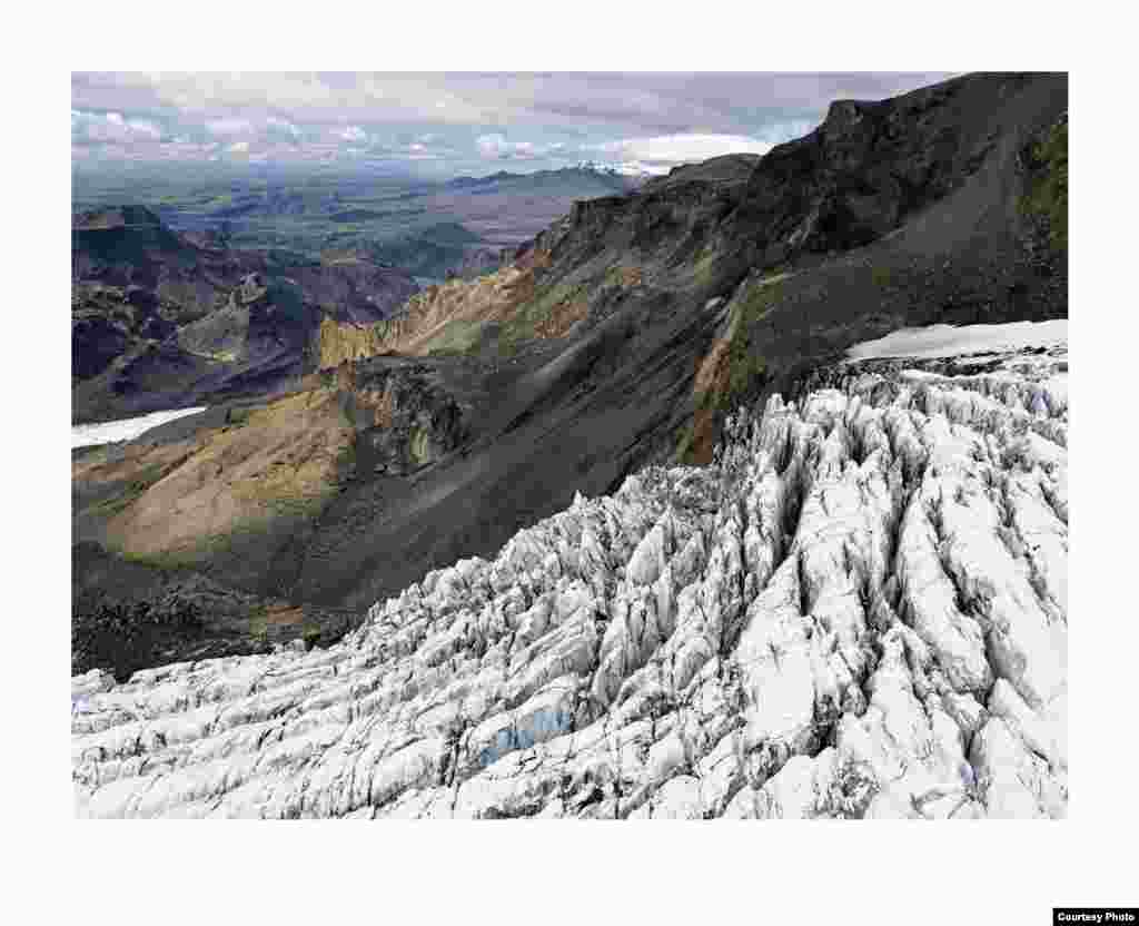 Aliran gletser dari lapisan es Mýrdalsökull. Pegunungan bersalju di latar belakang adalah sisa gunung berapi besar yang meletus 53.000 tahun yang lalu. (Feo Pitcairn Fine Art)