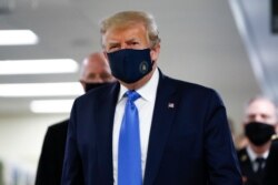 President Donald Trump wears a mask as he walks down the hallway during his visit to Walter Reed National Military Medical Center in Bethesda, Md., July 11, 2020.