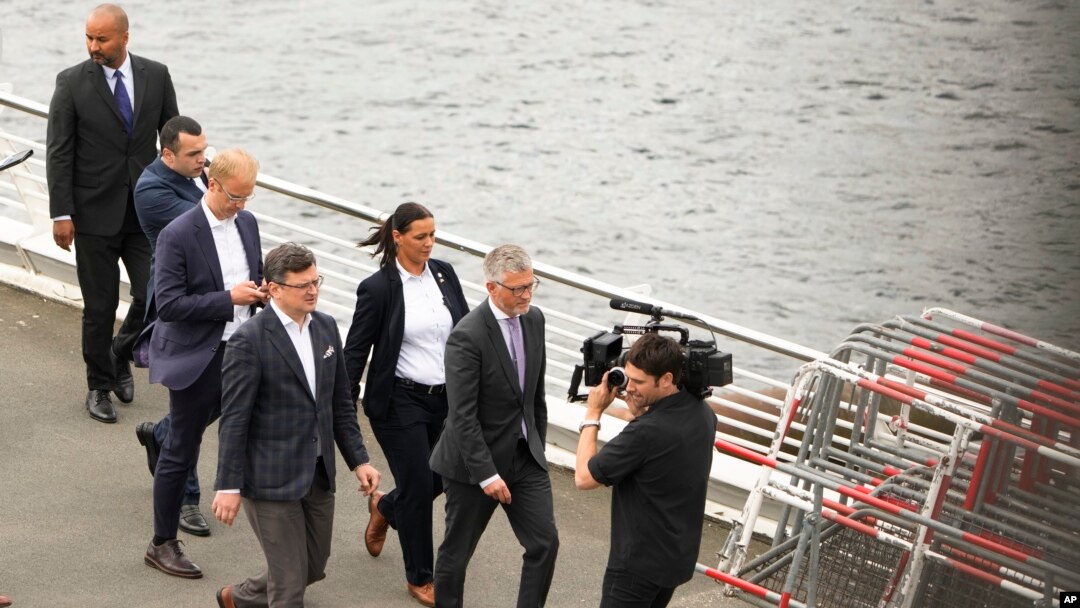 Menteri Luar Negeri Ukraina Dmytro Kuleba (tengah) dikelilingi oleh staf dan petugas keamanan ketika berjalan di Berlin setelah menghadiri sebuah pertemuan pada 12 Mei 2022. (Foto: AP/Markus Schreiber)
