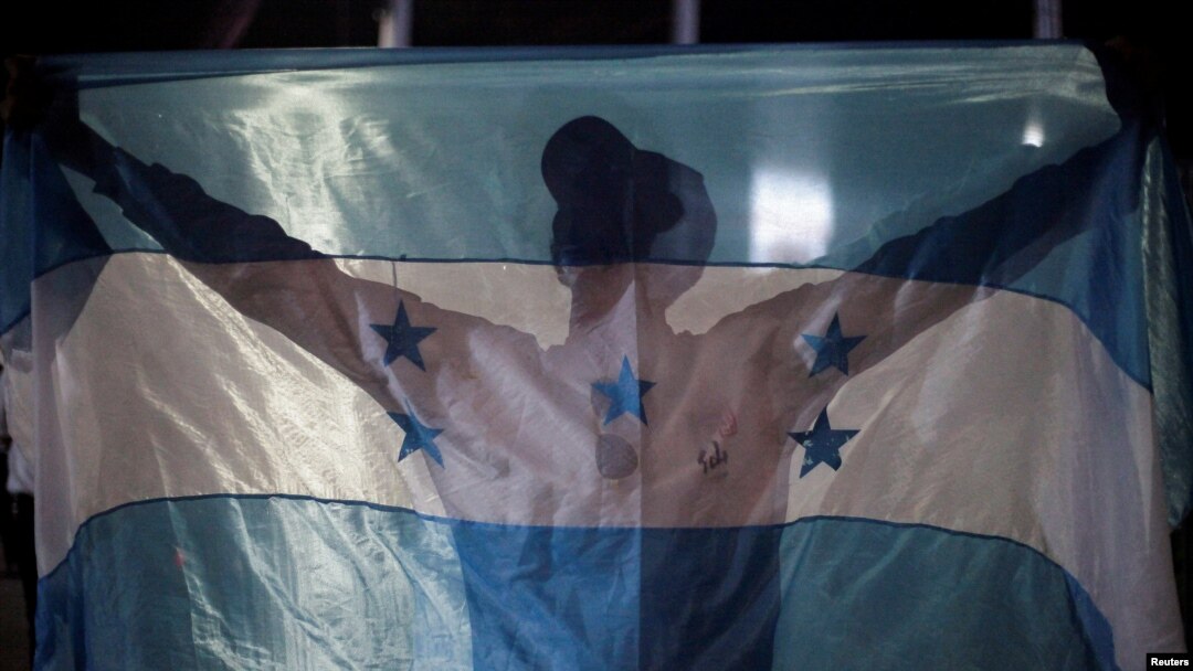 Un manifestante sostiene una bandera hondureña durante una protesta contra el gobierno de la presidenta hondureña Xiomara Castro y en apoyo al tratado de extradición con Estados Unidos, en Tegucigalpa, Honduras, el 6 de septiembre de 2024. 