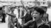 A Khmer Rouge soldier waves his pistol and orders store owners to abandon their shops in Phnom Penh, Cambodia, on April 17, 1975 as the capital fell to the communist forces. A large portion of the city&#39;s population was reportedly forced to evacuate. Photo from West German television film. (AP Photo/Christoph Froehder)&nbsp;