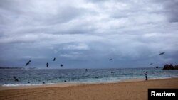 Un hombre mira la playa de La Empacadora en Cabo San Lucas, mientras el huracán Lorena se agita cerca del extremo sur de la península de Baja California en México el viernes por la tarde.