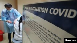 A medical staff member receives the Pfizer-BioNTech coronavirus vaccine at the at the CHR Centre Hospitalier Regional de la Citadelle hospital, in Liege, Belgium, Feb. 1, 2021.