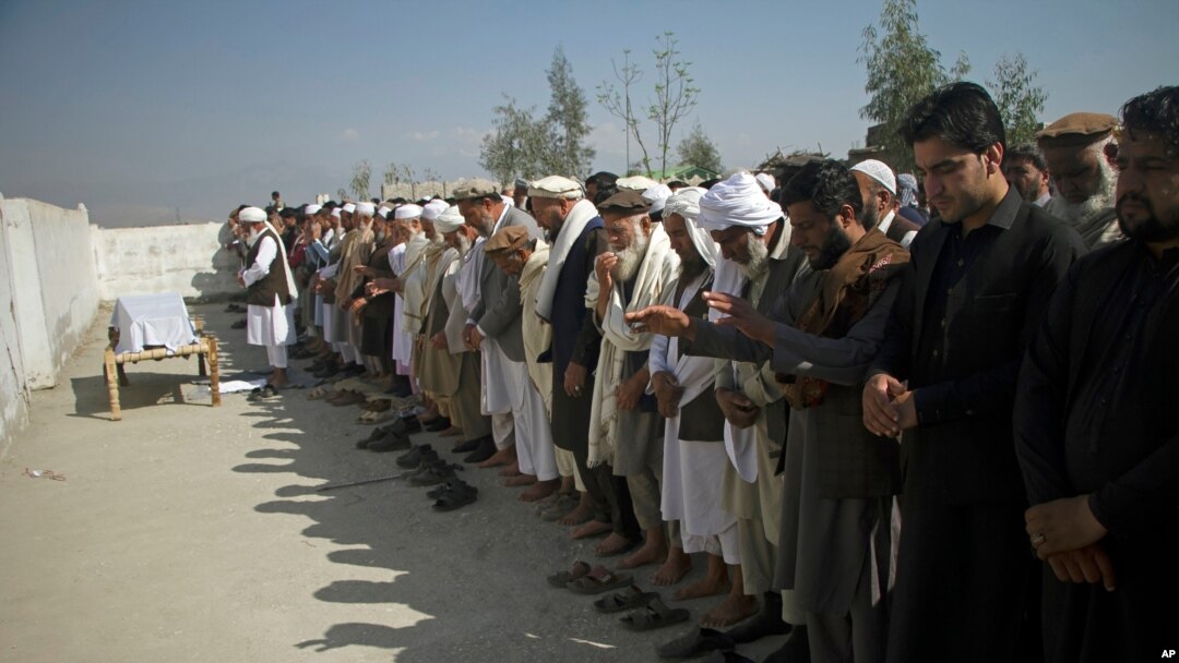 File - Relatives pray for one of three women working for a local radio and TV station who was killed on in attack during her funeral ceremony in Jalalabad, east of Kabul, Afghanistan, March 3, 2021. 