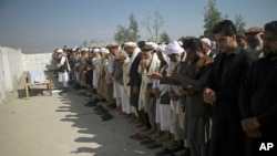 File - Relatives pray for one of three women working for a local radio and TV station who was killed on in attack during her funeral ceremony in Jalalabad, east of Kabul, Afghanistan, March 3, 2021. 