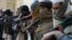 Afghan former Taliban fighters are photographed holding weapons before they hand them over as part of a government peace and reconciliation process at a ceremony in Jalalabad, Feb. 8, 2015. 