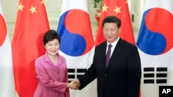 Chinese President Xi Jinping (R) shakes hands with South Korean President Park Geun-hye at the Great Hall of the People in Beijing, Sept. 2, 2015.