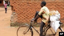 A man carries bags of fertilizer on his bicycle in Lilongwe, Malawi, Monday March 6, 2023. 