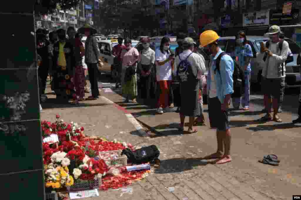 ရန်ကုန် ဆန္ဒပြပွဲအတွင်း သေနတ်ထိမှန်သေဆုံးသူများကို ၎င်းတို့ ကျဆုံးခဲ့ရာနေရာများမှာ ပန်းစည်း ပန်းခြင်းများနဲ့ အောက်မေ့ဂုဏ်ပြုခဲ့ကြတဲ့ မြင်ကွင်း။ (မတ် ၀၁၊ ၂၀၂၁) 