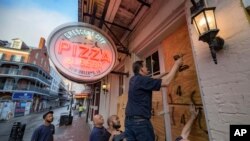 Michael Richard of Creole Cuisine Restaurant Concepts boards up Crescent City Pizza on Bourbon Street in the French Quarter before landfall of Hurricane Ida in New Orleans, Aug. 28, 2021.