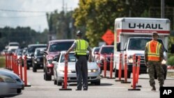 Anggota penegak hukum bekerja sama dengan Garda Nasional AS, mengarahkan lalu lintas di jalur jalan raya 501 (U.S. Highway 501) dekat Conway, South Carolina, saat Badai Florence bergerak mendekati Pantai Timur, Rabu, 12 September 2018, 