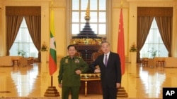 FILE - Myanmar's Army Commander and now the country's military leader, Gen. Min Aung Hlaing, left, and Chinese Foreign Minister Wang Yi pose for a photo during their meeting in Naypyitaw, Myanmar, Jan. 12, 2021. (Myanmar Military Information Team via AP)