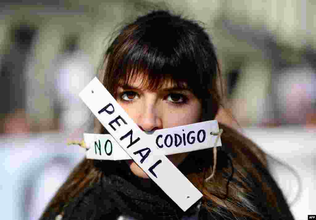 A woman covers her mouth with strips that read &quot;no penal code&quot; as she takes part in a demonstration called by the &quot;Dignity Marches&quot; against the new public security law, dubbed &quot;ley mordaza&quot; (gag law), in Madrid, Spain.