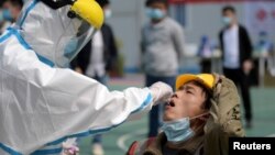 Nhân viên y tế lấy mẫu xét nghiệm virus corona cho người dân ở Vũ Hán, Trung Quốc, vào ngày 7/4/2020.