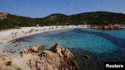 Para pengunjung di Pantai Ramizzo, di Teluk Zamrud, Pulau Sardinia, Italia, 7 Juli 2011. (Foto: Reuters)