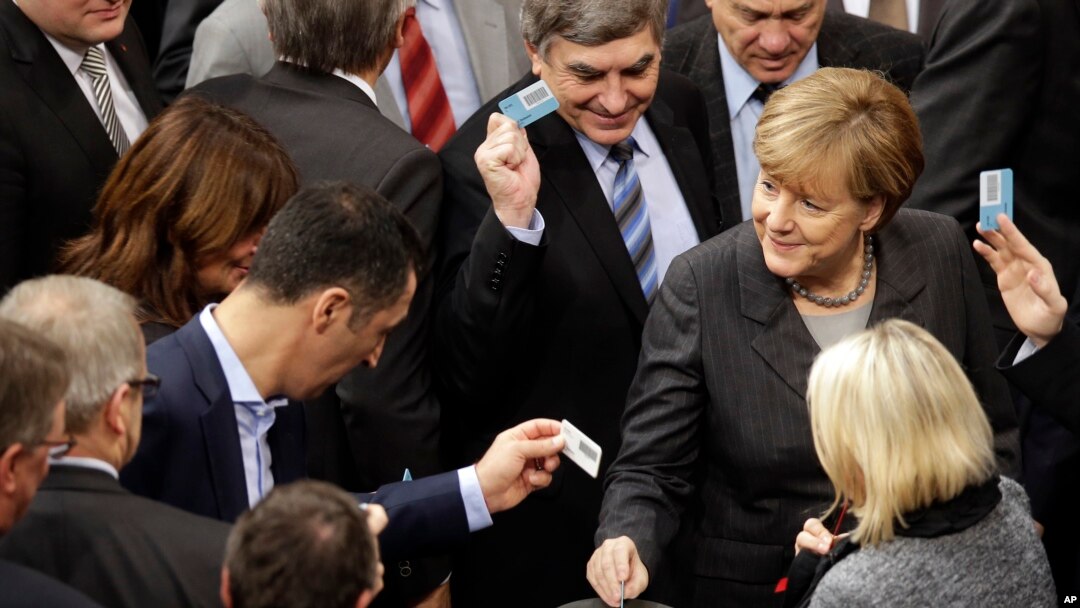 La canciller alemana Angela Merkel, a la derecha, vota este viernes en el parlamento de su país, en Berlin, Germany, Dec.4, 2015. 