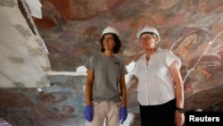 Pilar Roig Picazo, 75, and her daughter Pilar Bosch Roig, 42, work together on the restoration process at Santos Juanes in Valencia, Spain, September 17, 2024. (REUTERS/Eva Manez)