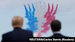 Presiden AS Donald Trump dan Presiden Perancis Emmanuel Macron menikmati atraksi udara di atas langit Normandia, pada peringatan 75 Tahun 'D-Day' hari Kamis (6/6).