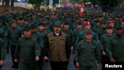 Venezuela's President Nicolas Maduro walks next to Venezuela's Defense Minister Vladimir Padrino Lopez and Remigio Ceballos, Strategic Operational Commander of the Bolivarian National Armed Forces, during a ceremony at a military base in Caracas, Venezuela.