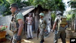 Seorang warga Tamil mengamati tentara Sri Lanka saat melakukan pencarian gerilyawan Macan Tamil di wilayah Jaffna, Sri Lanka (Foto: dok).