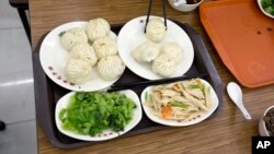 FILE - An order of food Qing-Feng Steamed Dumpling Shop in Beijing, China, Dec. 29, 2013. China's Food and Drug Administration says it found opium poppies used as illegal seasoning in 35 restaurants across the country, including a popular Beijing hot pot chain.