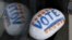 FILE - A stone painted with the word "VOTE" rests on the window sill of an art gallery in Peterborough, N.H., March 22, 2019. More than half of Americans want major changes to the system of government.