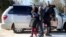 FILE - A family which claimed to be from Sudan, piles out of a Northern Taxi which drove them to the U.S.-Canada border in Champlain, New York, February 17, 2017. 