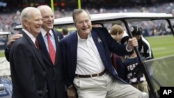 George H.W. Bush, derecha, se encuentra estable, pero médicos prefieren mantenerlo hospitalizado. En esta foto llegó hasta un partido de fútbol en Houston, el pasado 4 de noviembre.