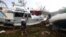 Local resident Bradley Mitchell inspects the damage to a relative's boat after it smashed against the bank after Cyclone Debbie passed through the township of Airlie Beach, located south of the northern Australian city of Townsville, March 29, 2017. 